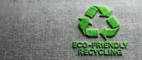 Green recycling symbol with eco-friendly text on textured gray fabric background for sustainable environmental awareness campaigns and green business.