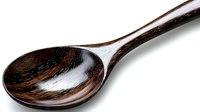 Rustic wooden spoon with deep brown grain pattern and glossy finish isolated on white background, ready for kitchen and dining presentations.
