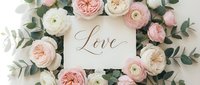 Romantic flat lay with pink and white roses, ranunculus, eucalyptus, and a card with calligraphy word Love, wedding decor concept.