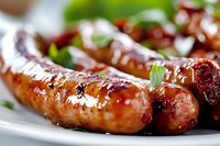 Grilled sausages with glossy caramelized surface and fresh herbs garnish on white plate, extreme close up macro shot showing juicy texture and char marks.
