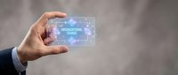 Businessman holding transparent digital device displaying organizational change concept with connected network icons and glowing interface elements.