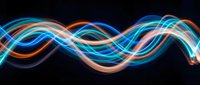 Glowing neon wave with flowing blue, orange, and pink light trails on dark background, suitable for tech, music, and digital design projects.