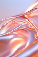 Luxurious rose gold and silver metallic fabric with smooth flowing waves and folds creates elegant abstract background with soft light and shadow play.