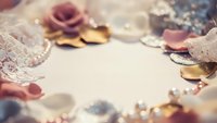 Elegant wedding accessories frame with lace, pearls, roses and golden details on soft background for bridal planning and romantic celebration design.
