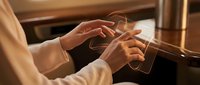 Professional businesswoman hands typing on smartphone screen in warm office lighting creating modern workplace communication atmosphere.