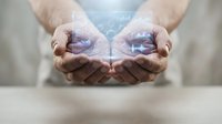 Cupped hands holding glowing blue energy orb with magical light effects for spiritual healing and wellness concepts.