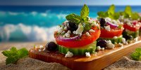 Fresh Mediterranean appetizer with tomatoes, olives and feta cheese on wooden board by tropical beach. Healthy summer food concept for restaurant menu design.