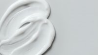 White cream swirl texture on light background for skincare cosmetic product design and beauty advertising applications.