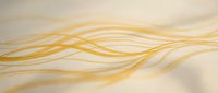 Thin golden strands interwoven on neutral background, suitable for healthcare, wellness, beauty, and scientific applications.