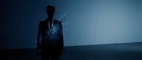Silhouetted male professional in formal business suit standing against blue gradient background with digital light effects and network connections symbolizing innovation and corporate leadership.