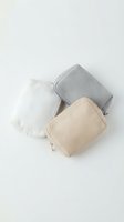 Minimalist cosmetic bags in neutral tones with marble texture on white background for beauty and travel organization.