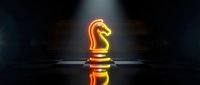 Glowing orange neon chess knight piece standing on reflective surface with dramatic lighting and dark background for strategic business concepts.