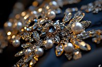 Elegant bridal jewelry with pearls and crystals in golden setting against dark background, featuring intricate floral design and sparkling details for wedding accessories.