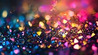 Vibrant multicolored glitter particles with bokeh effect on dark background creating magical festive atmosphere, soft focus macro photography.