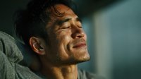 Middle-aged Hispanic man with eyes closed in peaceful meditation or relaxation moment, showing serene facial expression and emotional wellness.