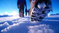 Winter hiking boots walking on fresh snow with dramatic low angle perspective, footprints leading into snowy mountain landscape against blue sky background.