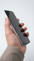 Hand holding modern smartphone with black screen and silver frame against white background, suitable for app promotion, technology marketing, and mobile device advertising.