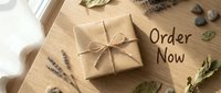 Kraft paper wrapped gift box with twine bow on wooden surface, surrounded by lavender and dried leaves, with Order Now text for shop promotion.