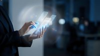 Businessman holding transparent tablet displaying glowing digital charts and graphs for financial analysis, data visualization, business intelligence, and corporate technology solutions.