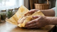 Senior woman hands holding fresh golden honeycomb in rustic kitchen setting with natural lighting and wooden surfaces for organic food concepts.