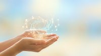 Cupped hands holding glowing digital brain with neural network connections against soft pastel sky background for AI technology and innovation concepts.