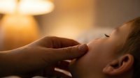 Young woman receiving relaxing head massage therapy in spa with warm ambient lighting for wellness and stress relief treatment.