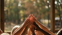 Diverse group of people joining hands together in roof shape gesture, symbolizing unity, teamwork, collaboration, and shared goals for community support and togetherness.