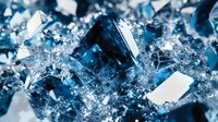 Macro shot of blue crystal formations with sharp geometric shapes and reflective surfaces in cold tones, creating abstract mineral texture background.