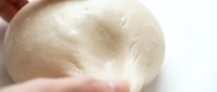 Close-up of hands kneading soft dough for baking, cooking, or culinary preparation and food preparation projects.