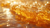 Glowing golden liquid with bubbles and sparkles in macro photography creates abstract background with bokeh effect and light reflections.
