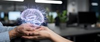 Businessman hands holding glowing digital brain hologram in modern office workspace representing artificial intelligence and innovative technology solutions.