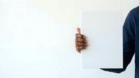 Businessman in dark suit peeking around white wall or door, showing thumbs up gesture. Concept for approval, agreement, positivity, business success, and professional recommendation.