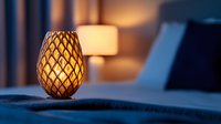 Glowing decorative pineapple-shaped lantern on bedside table creates cozy warm atmosphere in bedroom with soft evening lighting and blurred background.