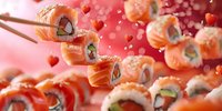 Fresh salmon sushi rolls with cream cheese and cucumber on pink romantic background with heart bokeh lights and wooden chopsticks holding roll.
