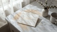 Elegant greeting card with gold hello script on marble surface near ceramic vase with eucalyptus and coffee cup in soft natural light.