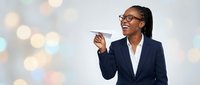Professional African American businesswoman in navy suit pointing and smiling against colorful bokeh background for corporate presentations.