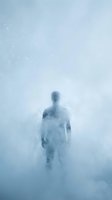 Male figure standing in dense fog or mist with ethereal, ghostly appearance. Cool blue tones create mysterious, surreal atmosphere. Suitable for conceptual, psychological, and editorial projects.