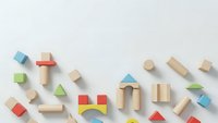Colorful wooden toy blocks scattered on white background. Educational building toys for children development and creative play activities.