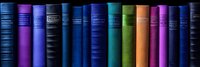 Row of colorful vintage hardcover books spines on dark background showing rainbow spectrum arrangement, suitable for education and literature concepts.