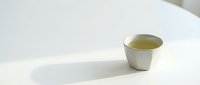 Ceramic cup filled with green tea on white background, isolated and ready for design use on packaging, websites, and marketing materials.