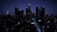 Downtown city skyline at night with illuminated skyscrapers and office buildings creating urban landscape for business and metropolitan concepts.