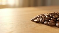 Roasted coffee beans scattered on wooden surface with warm sunlight, suitable for beverage, cafe, and food industry marketing materials.