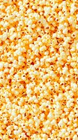 Fresh popcorn background with fluffy white kernels and golden yellow tones creates appetizing texture pattern for food industry and cinema marketing.