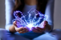 Female hands holding glowing magical blue butterfly effect with sparkles and light particles against dark background, mystical energy concept.