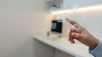 Hand touching futuristic holographic interface with digital icons and glowing elements in modern smart home environment for technology applications.