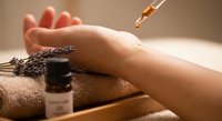 Relaxing spa aromatherapy treatment with essential oil dropper and lavender on towel for wellness and skincare routine.
