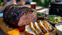 Grilled beef brisket with herb crust sliced on wooden board, barbecue sauce and fresh salad sides for outdoor dining and cooking presentations.