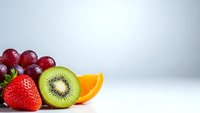 Fresh mixed fruits including strawberry, kiwi, orange and grapes arranged on white background for healthy eating and nutrition concepts.