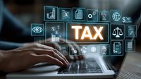 Person working on laptop with glowing TAX text and financial icons, representing digital taxation and accounting services.