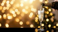 Champagne pouring into elegant flute glass against golden bokeh lights background for celebration and luxury lifestyle occasions.